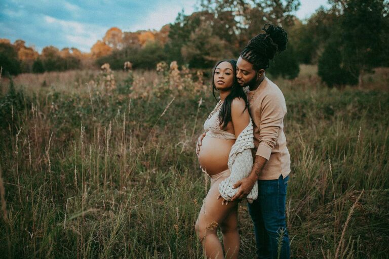 pregnant women posing with her husband during a maternity photo session near Carolina Birth and Wellness in durham