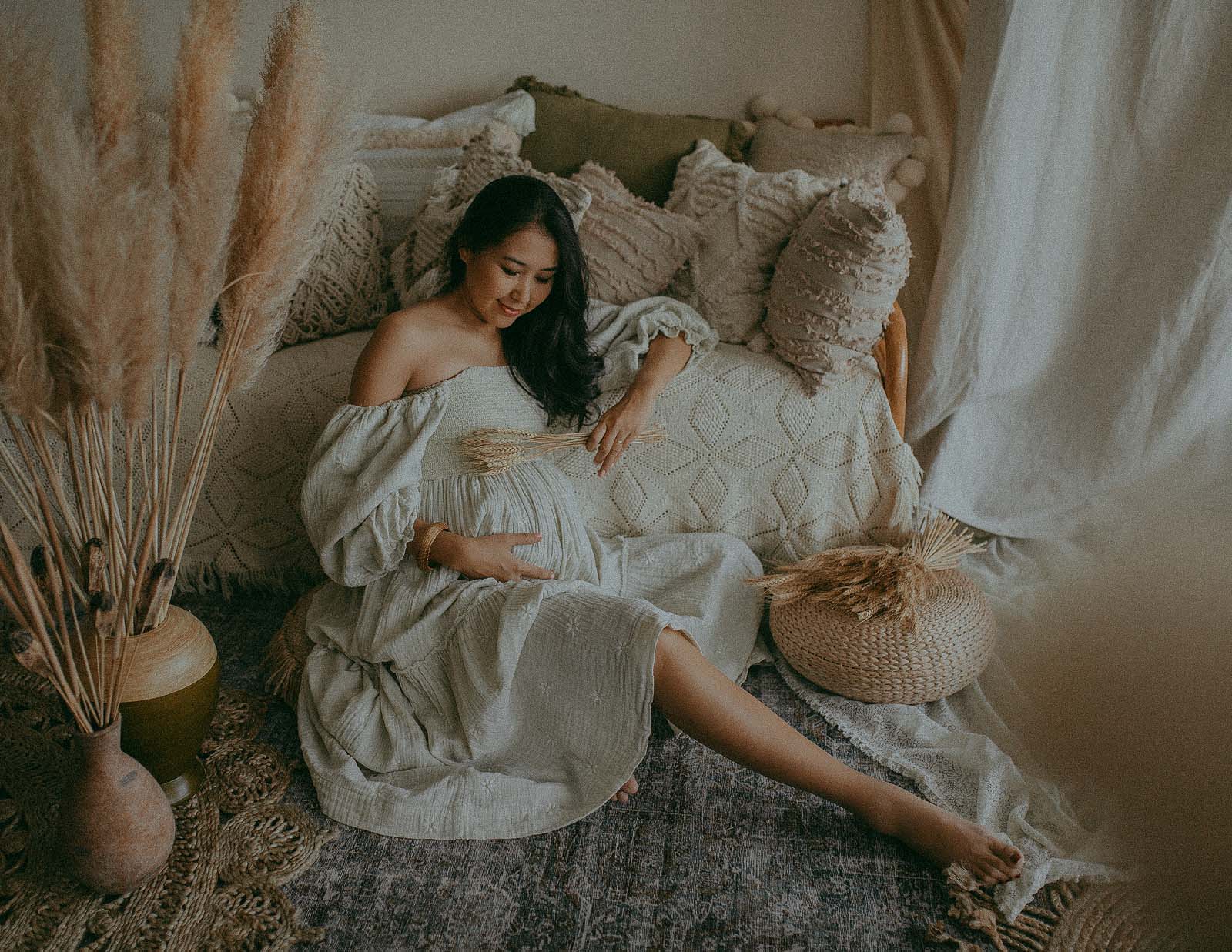gorgeous pregnant mama in boho maxi dress from free people brand is posing during her maternity photo session at photography studio in Apex NC