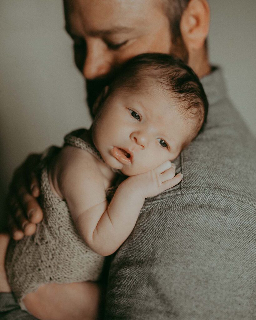 Through the lens of Chapel Hill photographer, Victoria Vasilyeva Photography, a dad shares a tender moment with her newborn baby girl, creating lasting memories of love and joy.