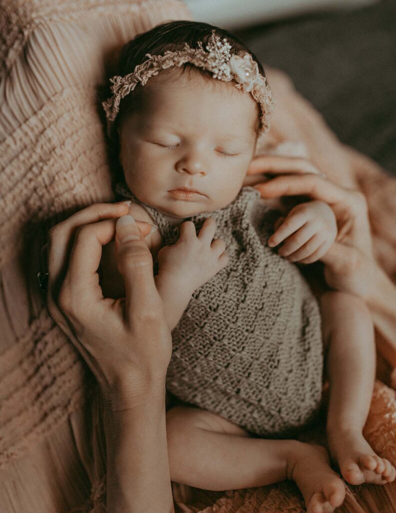 Chapel Hill newborn photographer, Victoria Vasilyeva Photography, captures a tender moment as a mom with short, curly blonde hair embraces her newborn baby girl in their enchanting photo session.