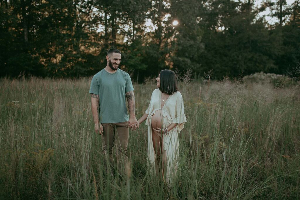 Victoria Vasilyeva Photography beautifully captures the joyous connection between a lovely pregnant couple, adorned in boho fashion, as they embrace following their rejuvenating prenatal massage experience in Fayetteville, NC.