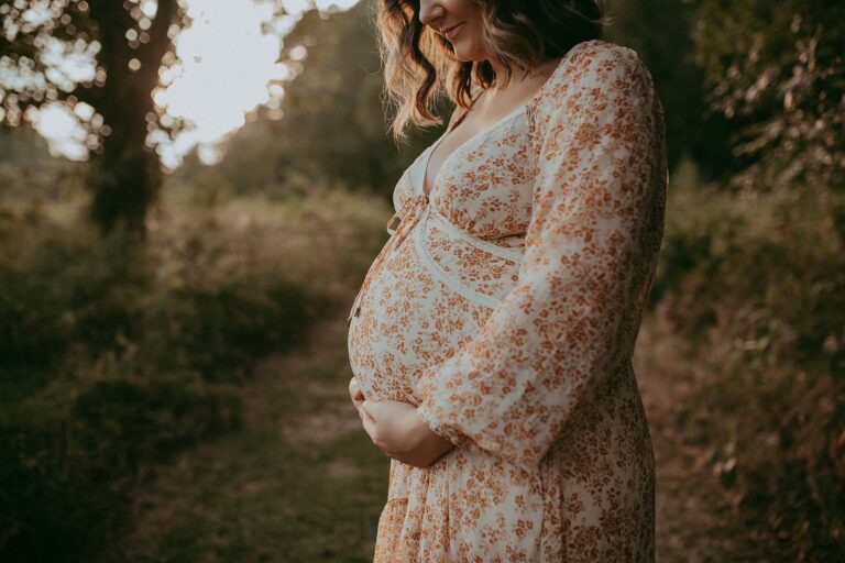 Nature's backdrop, love's embrace, and a stunning mom-to-be in a floral maxi dress. Victoria Vasilyeva Photography near Fayetteville doulas delivers a timeless outdoor maternity session.