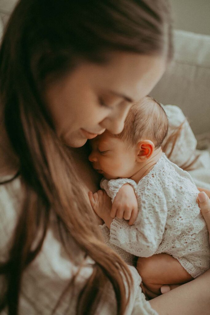 Capture the tender moments of a mother's love as she embraces her newborn baby in a heartwarming portrait session. Watch as pure affection unfolds, as the sleepy newborn snuggles close to mom. Newborn Portrait was taken by Fayetteville Newborn Photographer near Little Miracles Imaging.