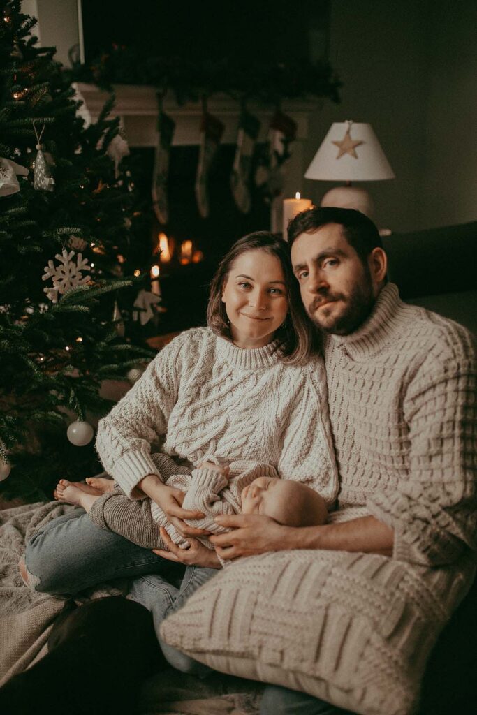 Mom, Dad, and baby girl celebrating their first Christmas together. The Christmas tree was recently bought at one of the Christmas tree farms near Raleigh NC. Victoria Vasilyeva Photography - Raleigh Family Photographer.