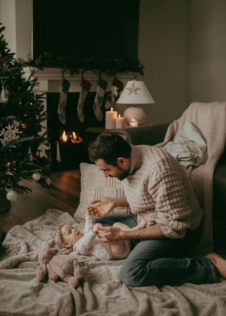 Holiday joy: A 5-month-old baby girl with her dad and their newly purchased Christmas tree. Family Photo Session was made by Victoria Vasilyeva Photography.