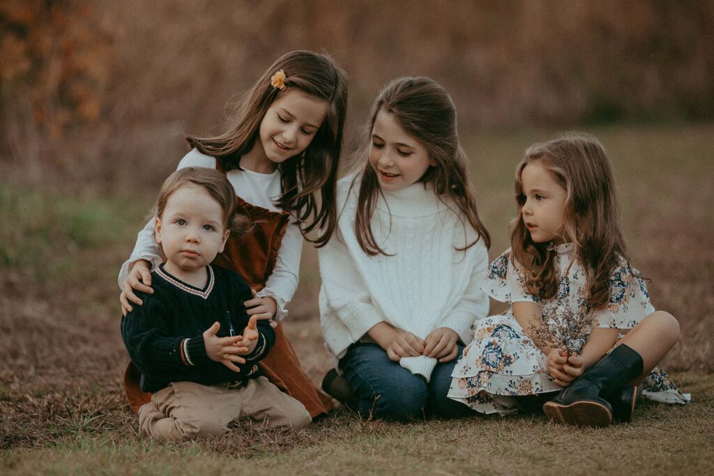 Three sisters and a little brother pose for a fun and playful photo session with Raleigh family photographer Victoria Vasilyeva Photography.