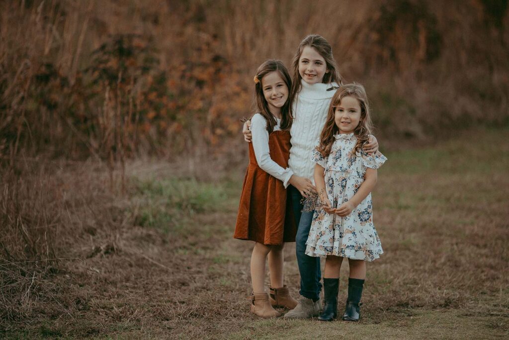 Three siblings share a moment of love and laughter during a photo session with Raleigh family photographer Victoria Vasilyeva Photography.
