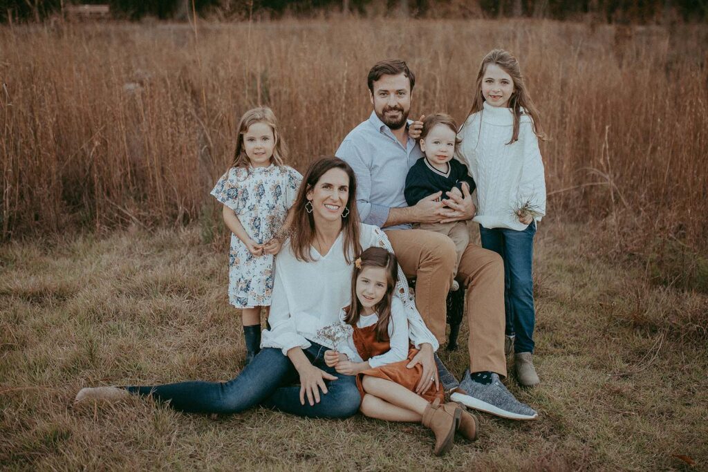 A large family enjoys a day of fall fun near pumpkin patch in Raleigh, NC during a family photo session with Victoria Vasilyeva Photography.