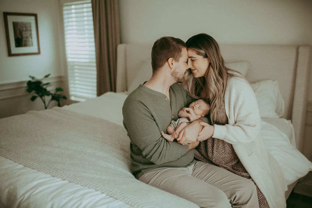 A boho-inspired family portrait captured by Holly Springs Newborn Photographer - Victoria Vasilyeva Photography, showcasing the unbreakable bond between parents and their newborn son.