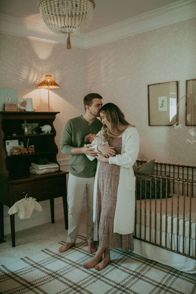 A newborn boy sleeps soundly in his boho-inspired nursery, surrounded by whimsical decorations and soft hues, creating a dreamlike atmosphere. Captured by Holly Springs Newborn Photographer - Victoria Vasilyeva Photography.
