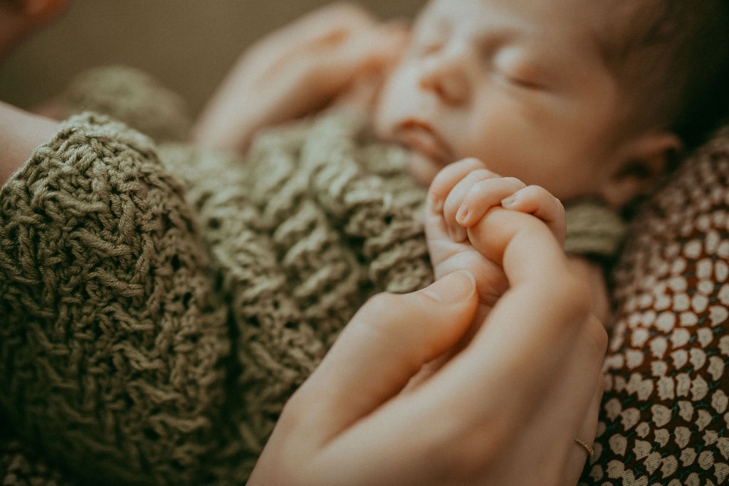 A tender moment of connection between a mother and her newborn son, beautifully captured by Holly Springs Newborn Photographer - Victoria Vasilyeva Photography.