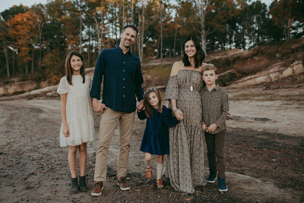 Southern Pines family vibes: Mom dons a boho Reclamation maxi dress, older girl sparkles in Zara, and the whole family radiates joy. Family portrait session by Victoria Vasilyeva Photography.
