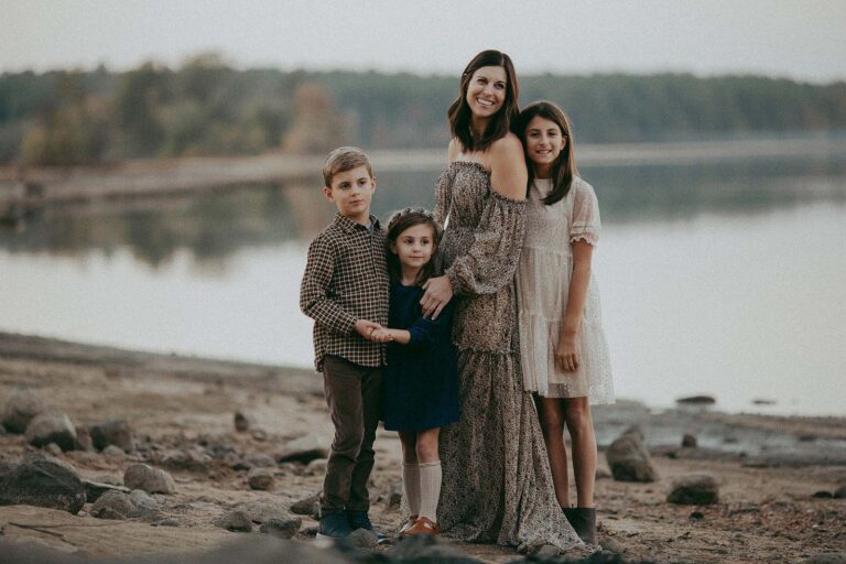 Captivating family portraits in Southern Pines, NC, highlighting the beauty of Belli Bambini and the family's trendy fashion choices. Mom wears a boho Reclamation maxi dress in brown tones. The older girl wears a Zara dress with glitter. The son wears stylish outfits from JCrew in brown tones. The little girl wears a dark blue dress and a flower halo. Family portrait session by Victoria Vasilyeva Photography.