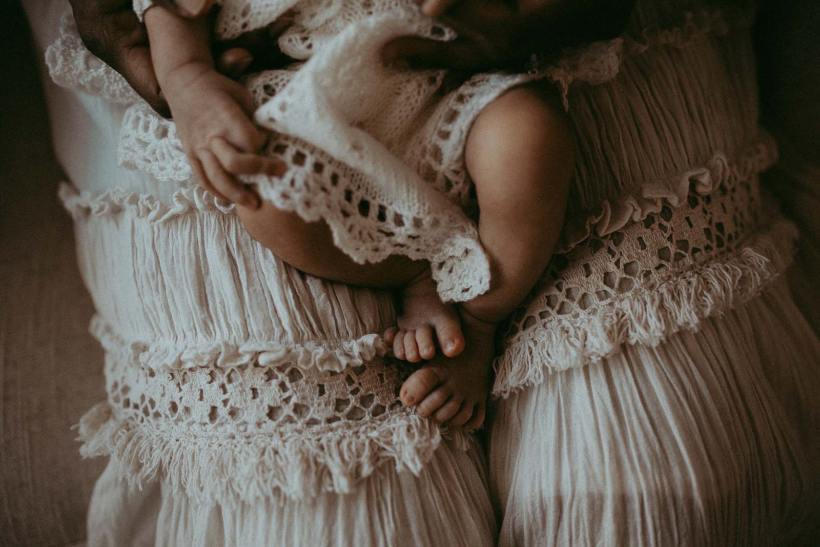 Tender moments captured by Victoria Vasilyeva Photography at Carrboro Midwifery, featuring a newborn boy in a delightful boho crochet white romper.