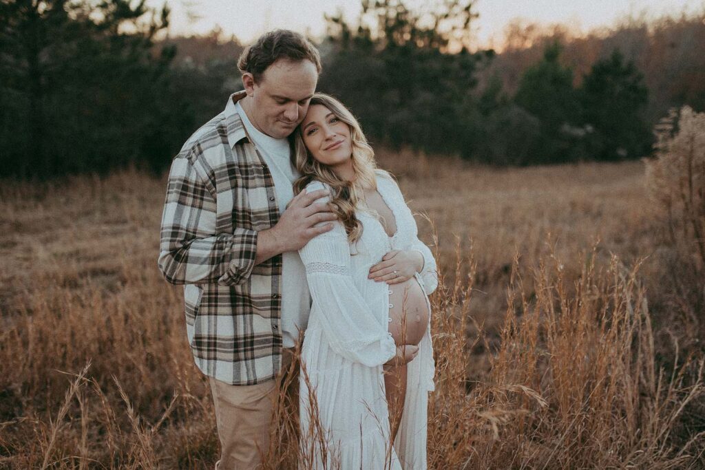 Expecting parents are enjoying the moment. Mom is leaning back to dad and he is hugging her shoulders. The portrait was taken by Victoria Vasilyeva Photography near Oh Baby 4D Ultrasounds in Clayton, NC.