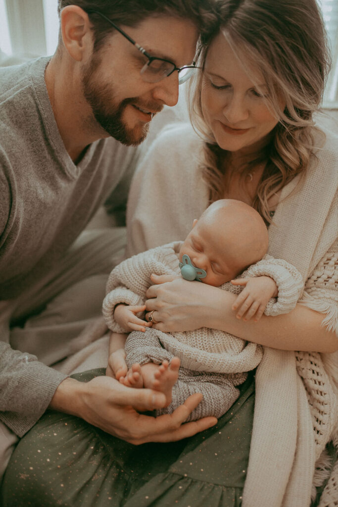 Family portrait with newborn baby boy. Newborn photographer in Cary, NC. Certified, insured, professional, safety. All outfits for baby, mom, and siblings are provided.