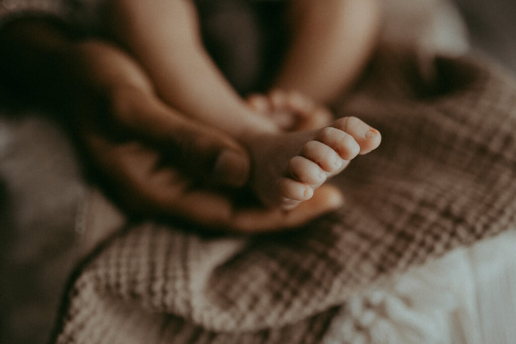 Tiny toes of newborn baby boy in mommy's hands. Greensboro newborn photographer.
