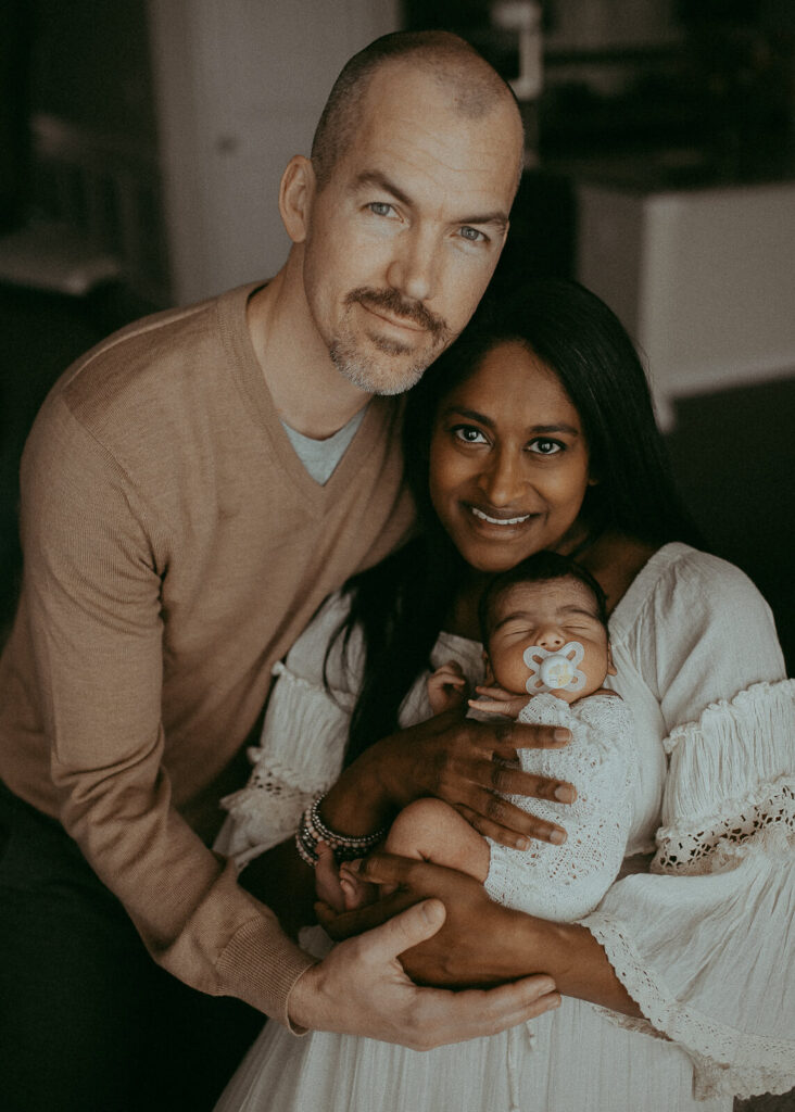 Newborn photo session with 4-days-old baby boy and his family. The portrait of mom, dad and baby in white romper was taken by Victoria Vasilyeva Photography - Certified, insured, and professional Greensboro photographer.