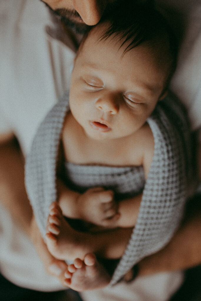 Wrapped in love: Dad gaze adoringly at Matthew, their precious newborn, in a photo by Victoria Vasilyeva Photography.