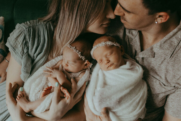 A family portrait of pure happiness with Mom, Dad, and their twin wonders in floral headbands. Newborn Photo Session with Victoria Vasilyeva Photography took place near Raleigh nanny agency.