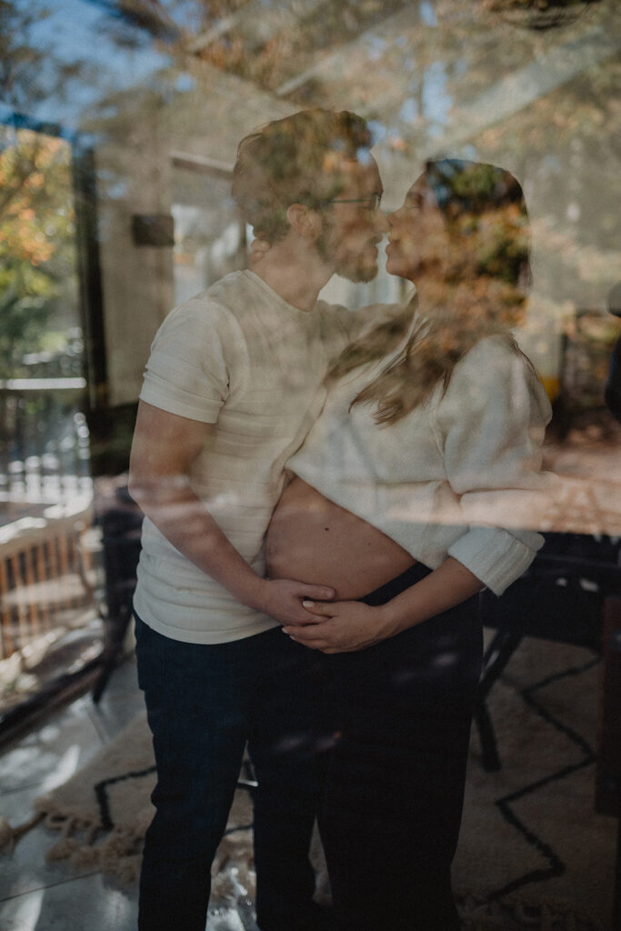 Artistic reflection of an expecting couple sharing an intimate moment, symbolizing emotional connection, mindfulness, and prenatal wellness supported by Moonshadow Medical Massage.