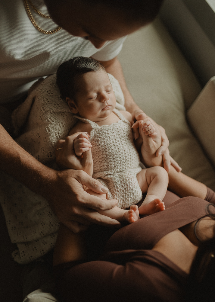 Overhead view of a newborn resting peacefully on a mom’s lap during a feeding break, showing gentle hands-on support. Lactation consultant Cary NC.