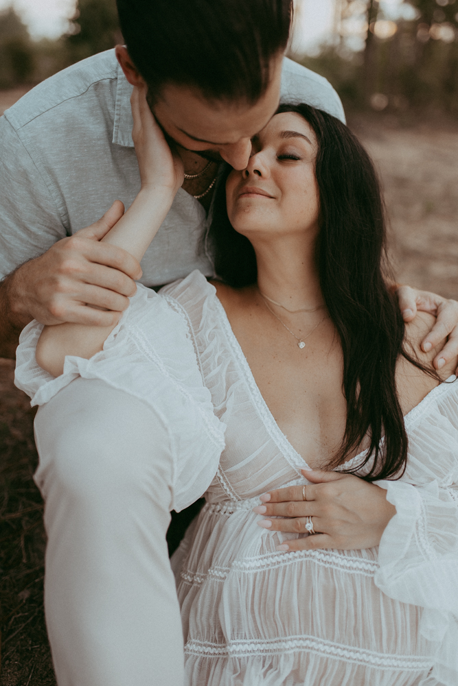 Romantic maternity portrait of a couple sharing a quiet moment outdoors near the lake as they await their baby, maternity photography Cary NC by Victoria Vasilyeva Photography.
