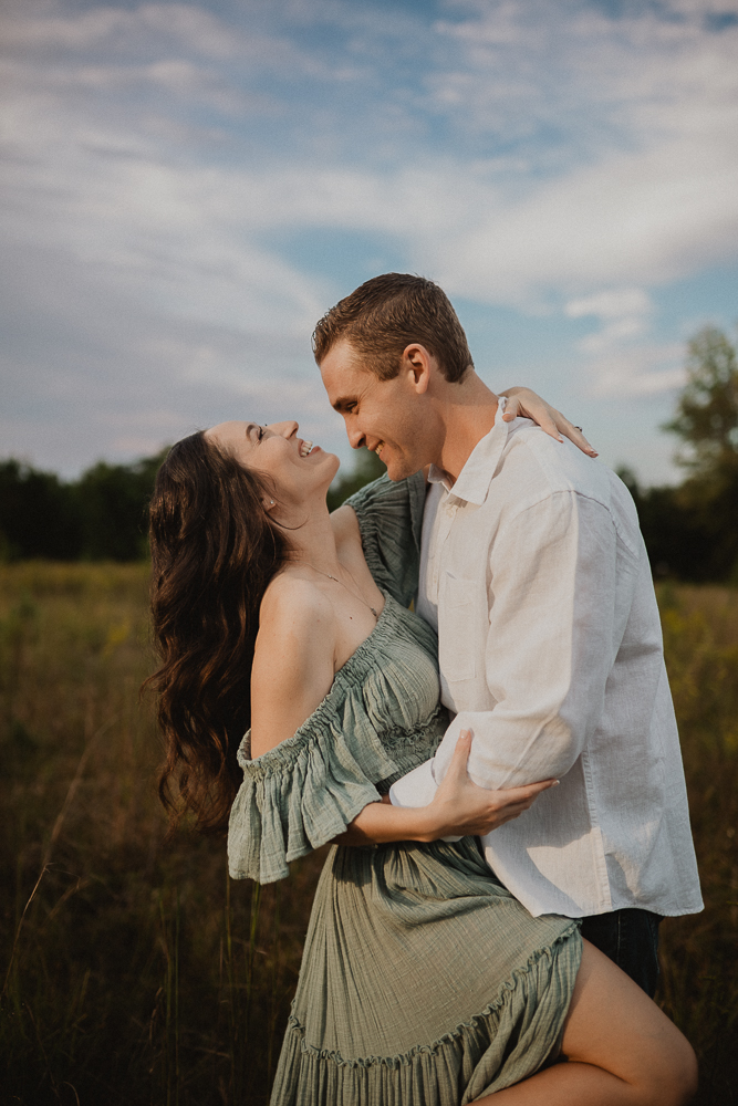 Outdoor maternity session showing expecting parents laughing and celebrating their fertility journey with a Raleigh Fertility Clinic. Photo by Raleigh maternity photographer.