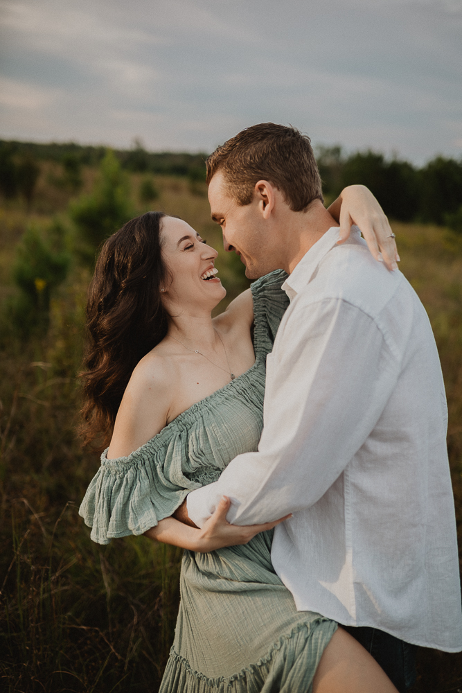 Joyful couple embracing during maternity photoshoot, celebrating pregnancy supported by a Raleigh Fertility Clinic. Captured by Raleigh maternity photographer Victoria Vasilyeva Photography.