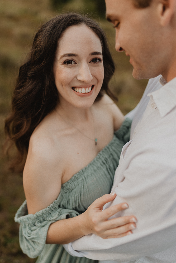 Expecting mother smiling during golden-hour maternity session after working with a Raleigh Fertility Clinic. Photo by Raleigh maternity photographer.