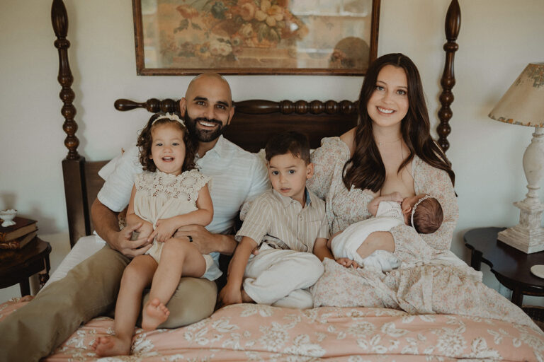 Raleigh family of five posing with their newborn baby during a lifestyle newborn session focused on connection and family bonding.