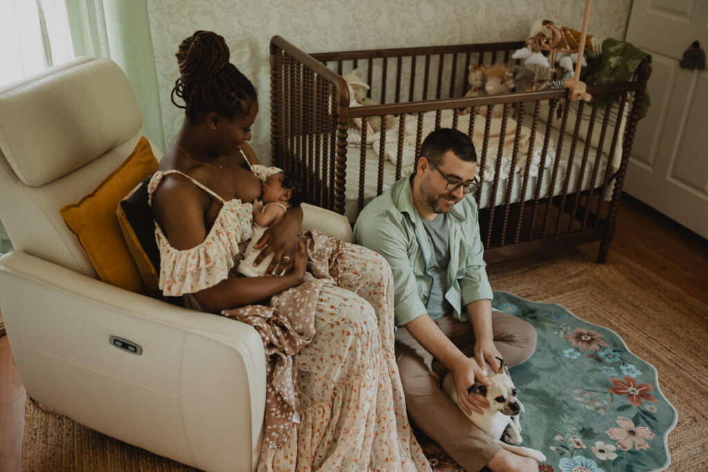 Goodnight Sweet Baby. Parents relax together in the nursery with their newborn and family dog, creating authentic everyday memories during a lifestyle session with Raleigh newborn photographer Victoria Vasilyeva Photography.