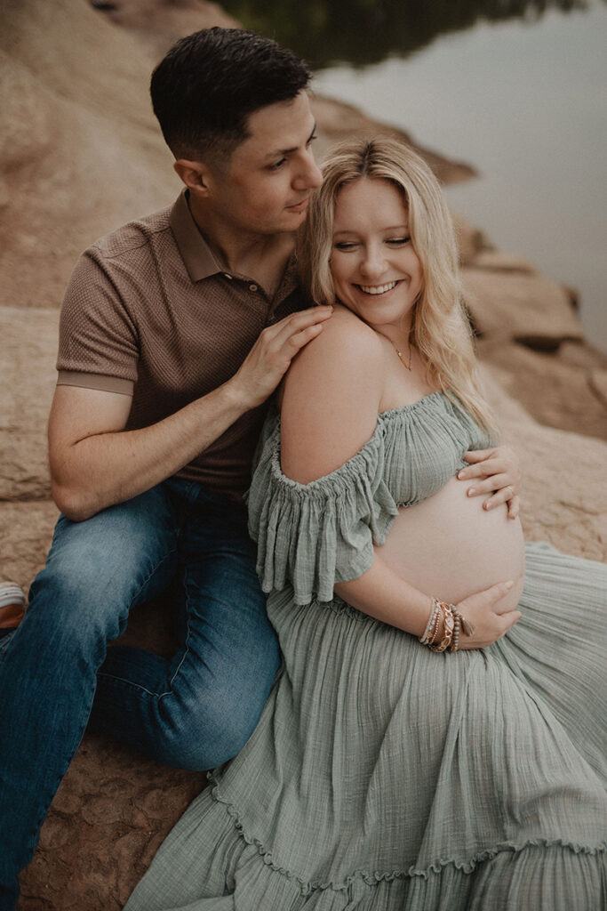 Joyful expectant parents embracing during an outdoor maternity session with a Wake Forest photographer