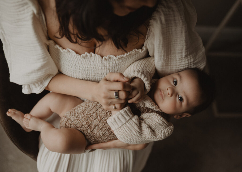Mother holding her baby boy in her arms during a relaxed in-home family session photographed by Chapel Hill family photographer Victoria Vasilyeva Photography.