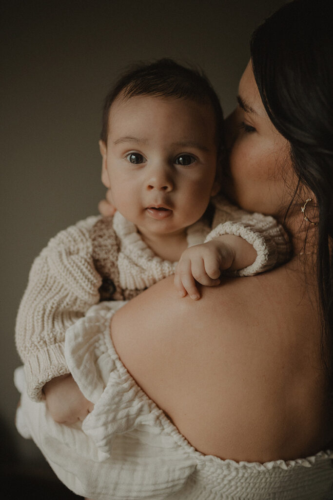 Chapel Hill family photographer capturing a sweet close-up of a baby in his mother’s arms during a relaxed in-home family photo session.
