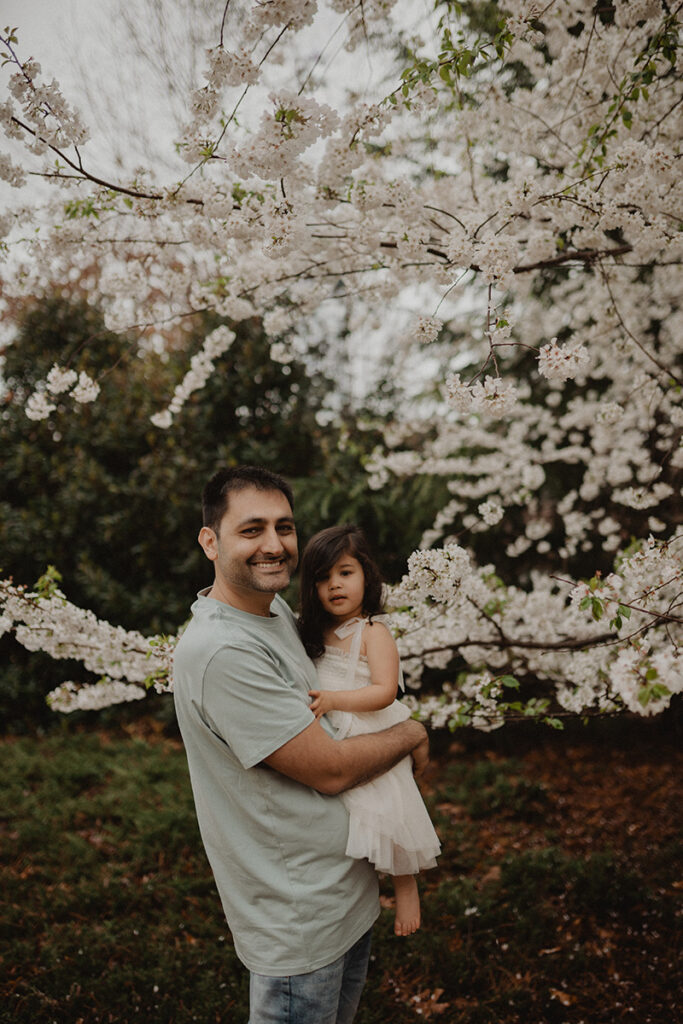 In-home family photography in Chapel Hill by Victoria Vasilyeva Photography, featuring parents cuddling their baby boy and capturing genuine connection in natural light.