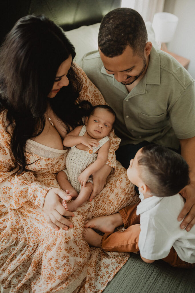 Parents and toddler gathered around their newborn baby boy during a warm family session in Raleigh, with care supported by Honeysuckle Lactation Consultants.