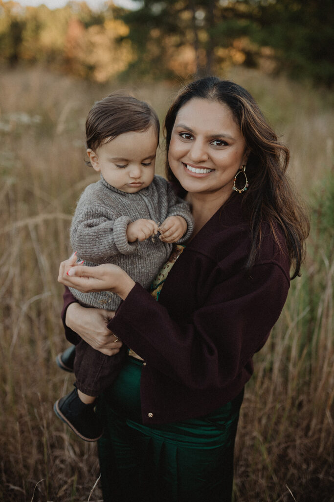 Mother holding her young son during a warm fall family photo session at a pumpkin patch near Durham, NC.