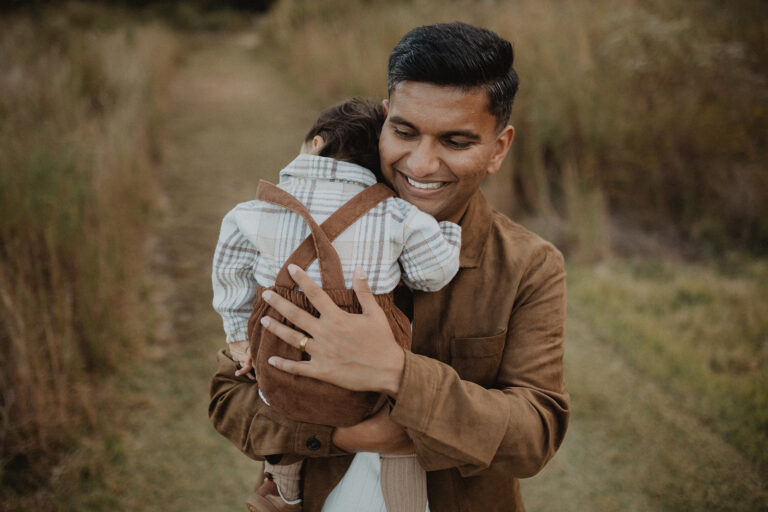 Father hugging his young son during a family portrait session by Victoria Vasilyeva Photography at Holder Hill Farm in Durham, NC.