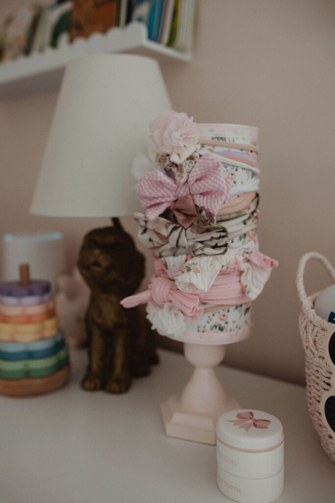 Collection of floral baby headbands displayed in a baby girl's nursery during a lifestyle newborn photography session by Victoria Vasilyeva Photography in Raleigh NC.