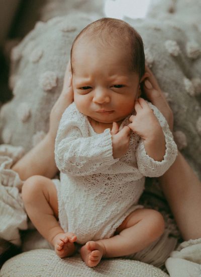 The portrait of newborn baby boy in white knitted romper taken by Raleigh newborn photographer - Victoria Vasilyeva Photography.
