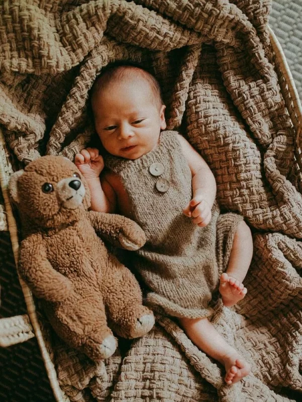 newborn baby with teddy bear in woven basket